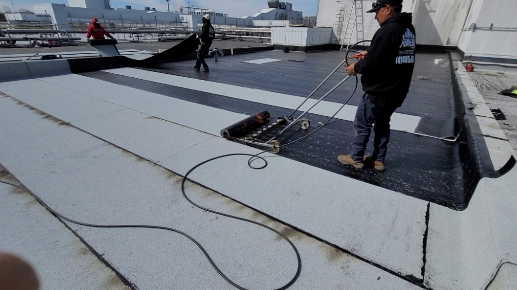 Three men working together on the roof