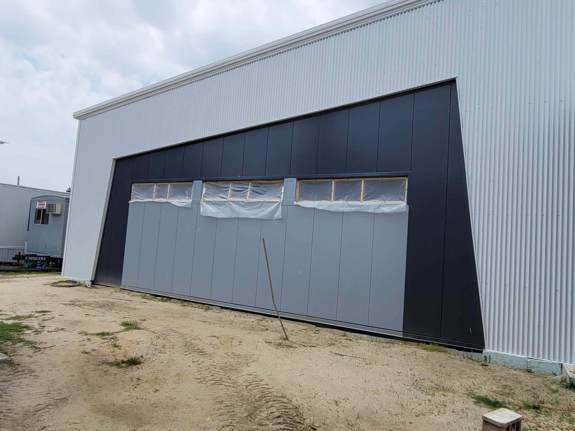 Exterior of a commercial building with a large gray, black door