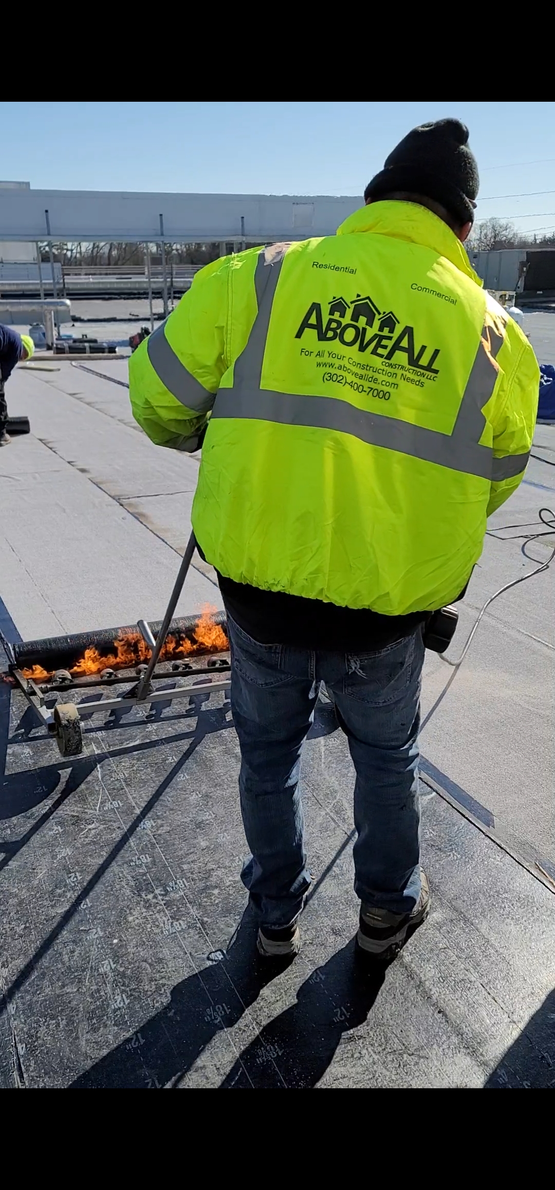 Man wearing a neon yellow Above All Construction jacket