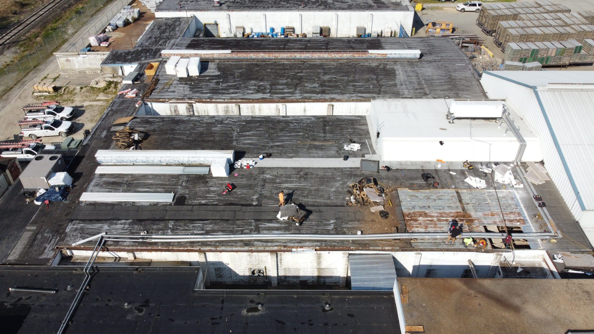 Above All Construction workers on a roof of a commercial building