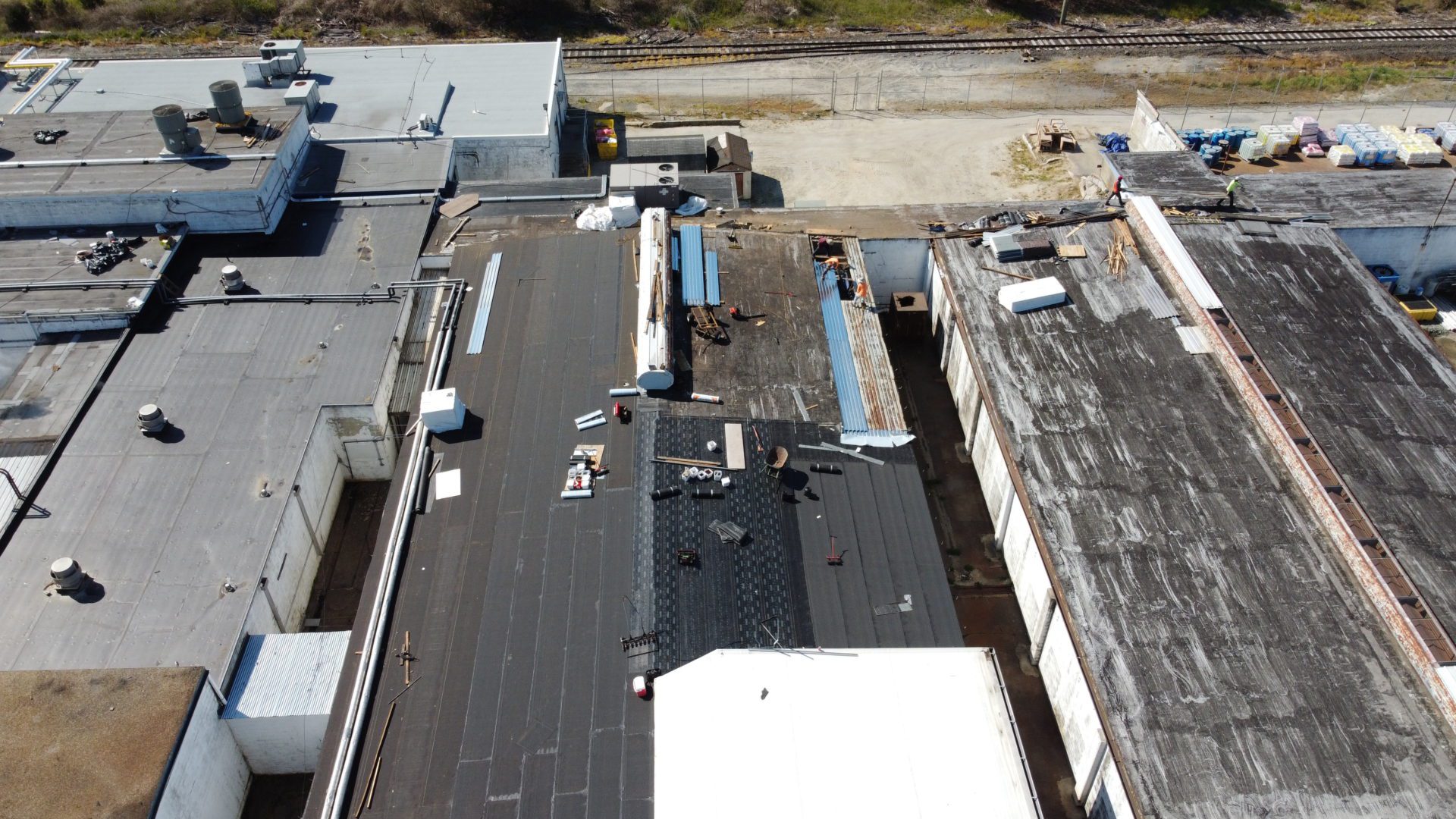 Aerial view of an industrial building with new roofing by Above All Construction